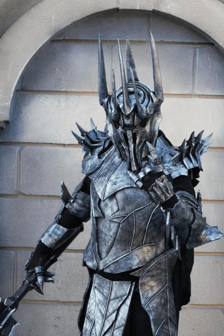 Left-side view of the Dark Realm Warlord cosplay costume showing cape, armor layers, and a strong stance.