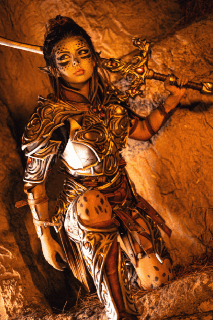Front view of a woman wearing the Fierce Warrior Armor cosplay costume, holding a sword, featuring EVA foam armor with metallic battle-worn detailing.